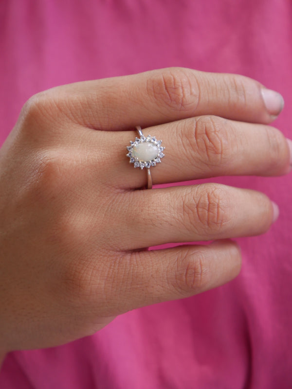 opal ring with tanzanite halo around ring white and blue gemstone ring, natural stone. Rare gemstone rings, unique. Trending dainty rings. Dainty ring with crystals for good luck. Waterproof dainty rings. Designer inspired rings. Everyday rings. Cute jewelry. Unique rings. rings for love and good luck. White gold, .925 sterling silver. Popular rings for gift. meaningful birthstone jewelry.